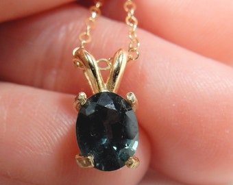 Dark lustrous blue Montana sapphire in 14kt gold basket pendant - the birthstone for September
