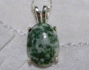 May include: A silver chain necklace with a green and white agate pendant. The pendant is oval shaped and has a mottled pattern.