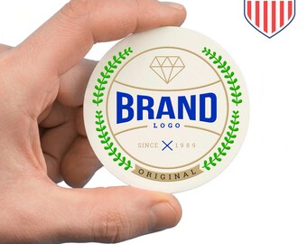 May include: A round, off-white coaster with a diamond graphic and the word "BRAND" in blue. The coaster is encircled by a green leafy design and the text "SINCE 1989 ORIGINAL". A "Made in the USA" emblem is in the upper right corner.