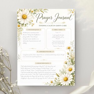 May include: A prayer journal page featuring white daisy illustrations with green foliage. The text reads Prayer Journal, Finding Calm in God's Care, Prayer Requests, Bible Verses, Answered Prayers, and Reflection Notes with lined writing sections.