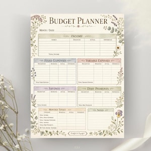 May include: A budget planner sheet featuring the title BUDGET PLANNER at the top, with sections for income, fixed expenses, variable expenses, savings, debt payments, monthly totals, and notes, all decorated with watercolor floral illustrations.