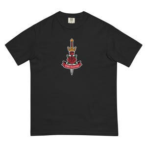 Può includere: T-shirt nero con una grafica centrale raffigurante una spada che trafigge una rosa rossa, sormontata da una corona d'oro e uno stendardo con la scritta "FMC Energy".