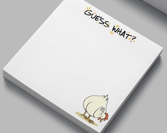 Puede incluir: Una pila de notas adhesivas blancas con el texto "GUESS WHAT?" en negro. Un dibujo animado de un pollo está en la esquina inferior derecha. El pollo es blanco con patas amarillas y una cresta roja. Las notas están sobre una superficie gris.