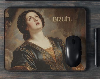 May include: Rectangular mousepad featuring a Renaissance painting of a woman looking upwards, with the word "BRUH." in a sans-serif font. A black computer mouse and pen are next to the mousepad on a wooden surface.