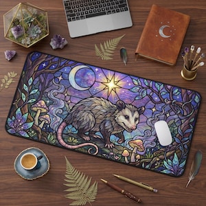 May include: A rectangular mousepad featuring a stained-glass design with a possum, mushrooms, and a crescent moon. The color palette includes purple, blue, and green hues. A white computer mouse rests on the pad.