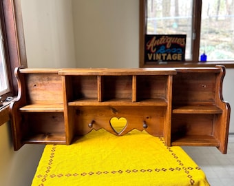 Estantería flotante de pared estilo campestre vintage con recorte en forma de corazón.