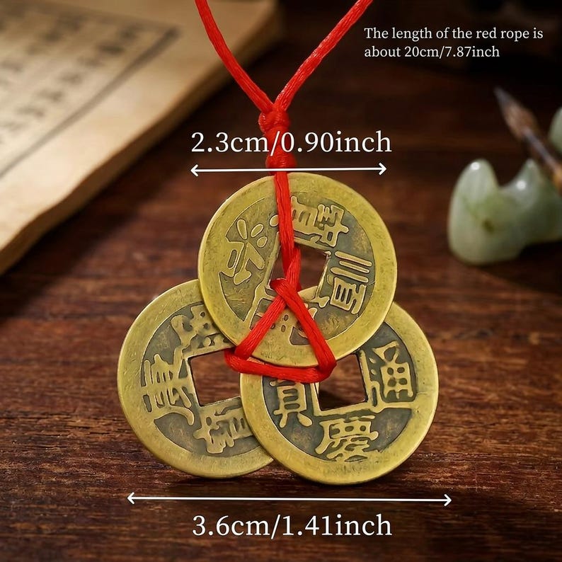 May include: Three antique bronze Chinese coins strung on a red cord. The coins are 1.41 inches wide and 0.90 inches in diameter. The red cord is 7.87 inches long. The coins have Chinese characters.