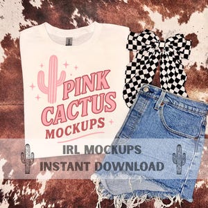 Op de afbeelding: Wit T-shirt met een roze cactusafbeelding en de tekst "PINK CACTUS MOCKUPS". Inclusief een spijkerbroekshort en een zwart-wit geblokte strik. De afbeelding bevat ook de tekst "IRL MOCKUPS INSTANT DOWNLOAD".