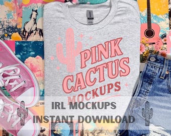 May include: A grey t-shirt featuring a pink cactus graphic and the text "PINK CACTUS MOCKUPS". The image includes denim shorts and pink trainers. The words "IRL MOCKUPS" and "INSTANT DOWNLOAD" are also visible.