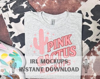 May include: A grey t-shirt featuring a pink cactus design and the words "PINK CACTUS". The shirt is shown with cow print jeans and a pair of white and colourful trainers. The text "IRL MOCKUPS INSTANT DOWNLOAD" is also on the shirt.