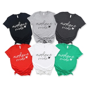 a collection of six t-shirts, each with the text "airplane mode" printed on them in different colors and styles.