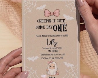 May include: A Halloween-themed invitation card with the text "CREEPIN IT CUTE SINCE DAY ONE" and event details. The card is decorated with spiderwebs, bats, and a cute ghost illustration. Two pink pumpkins and a bat cutout are also visible.