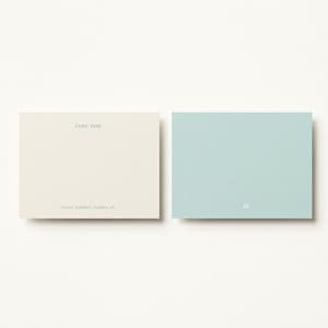 Soft blue and ivory personalized stationery duo displayed in a clean editorial flat lay, elegant custom correspondence set for bridal shower thank you notes, baby shower cards, thoughtful hostess gift, feminine desk accessories, chic writing paper set, modern social stationery, custom monogram note cards, luxury gift for newlyweds, pastel office decor aesthetic, refined paper goods for everyday notes, stylish personalized paper set for women and professionals