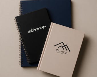 May include: Three notebooks stacked together. The bottom notebook is dark blue with a spiral binding. The middle notebook is black with a spiral binding and the white text "add your logo". The top notebook is beige with a mountain logo and "ADD YOUR LOGO HERE".