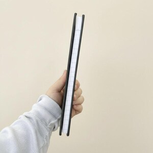 Slim personalized striped notebook shown in side profile, highlighting the elegant hardcover thickness and clean binding. Features custom monogram design in a preppy style, ideal for bridesmaid gifts, teacher appreciation presents, student stationery, office desk accessories, journaling, and everyday note taking.