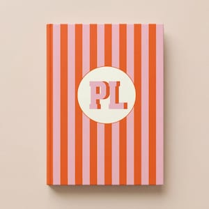 Personalized striped hardcover notebook in orange and blush pink with custom monogram initials on a cream circle, luxury preppy journal gift for women, custom bridesmaid notebook, sorority style planner, aesthetic desk accessory, feminine stationery, personalized school notebook, chic office journal, monogram notebook for college student, stylish writing journal, custom name notebook gift, boutique stationery present, rich girl aesthetic desk decor, elegant striped diary, custom notebook