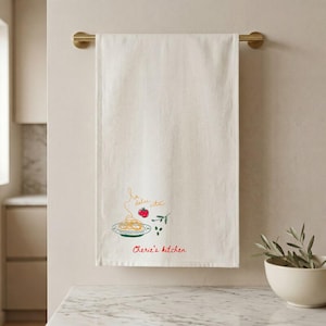 Custom tea towel displayed on modern kitchen towel bar, personalized home gift, elegant linen hand towel, bridal shower present, neutral kitchen decor, luxury hostess gift, housewarming surprise, realtor client closing gift, custom embroidered towel keepsake. Perfect for newlywed couples, apartment decor, Airbnb styling, holiday hosting, birthday gifts, farmhouse home accents, thoughtful everyday essentials, premium bathroom linen display, and elevated interior design lovers.