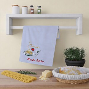 tea towel hanging elegantly beside marble cabinetry, decorative cooking accessory, tasteful residential textile, charming breakfast decor, polished entertaining accent, graceful farmhouse furnishing, refined household styling, cozy culinary atmosphere, fashionable apartment detail, beautiful woven material, elevated domestic presentation, curated kitchen aesthetic, sophisticated brunch companion, stylish pantry arrangement, delicate floral artwork, upscale homemaker favorite