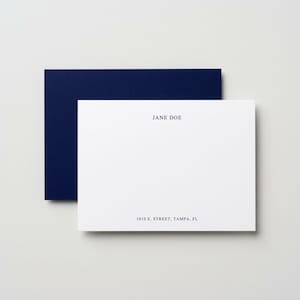 Custom navy blue flat note cards with matching envelopes displayed in a minimalist neutral flat lay, elegant personalized stationery set featuring modern correspondence cards, monogram thank you note set, luxury writing paper gift, professional business stationery, wedding thank you cards, premium folded note cards with envelopes, sophisticated dark blue paper goods, refined desk accessories, personalized correspondence set for women, timeless stationery gift idea, high end minimalist paper