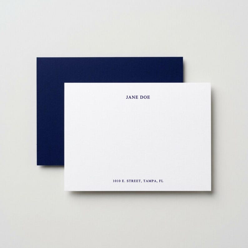 Custom navy blue flat note cards with matching envelopes displayed in a minimalist neutral flat lay, elegant personalized stationery set featuring modern correspondence cards, monogram thank you note set, luxury writing paper gift, professional business stationery, wedding thank you cards, premium folded note cards with envelopes, sophisticated dark blue paper goods, refined desk accessories, personalized correspondence set for women, timeless stationery gift idea, high end minimalist paper