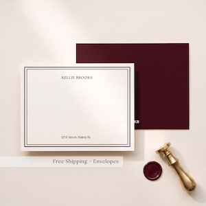 May include: A white stationery card with a dark maroon double-line border, featuring the printed name KELLIE BROOKS and the address 123 E Street, Maimi, RL. A matching dark maroon envelope with the initials KB and a brass wax seal stamp are included.