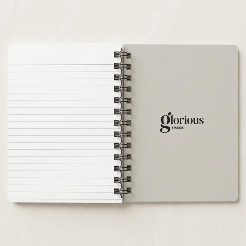 Minimalist tan spiral notebook mockup with gold custom logo beside open lined pages. Elegant and professional journal for branding, business stationery, and office gifts. Great for personalized executive planners, corporate meeting notebooks, and business logo journals. Customizable writing pad ideal for client presentations, office supplies, or business events. Premium spiral notebook designed for professionals and entrepreneurs.