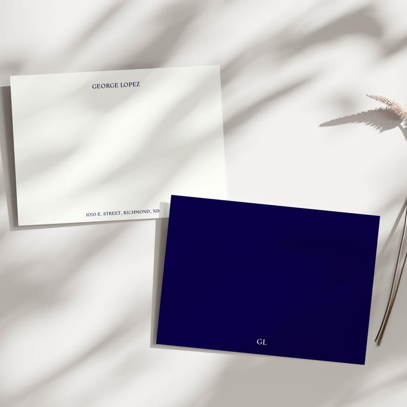 May include: Two stationery cards. One is white with a navy blue border and text that reads "SAMANTHA GREGORY" and an address. The other card is navy blue with the initials "SG" in white.