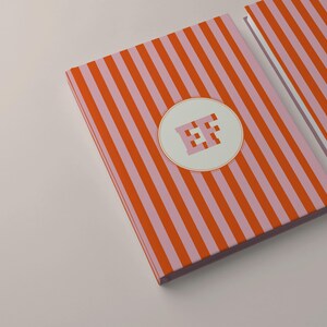 Orange and pink striped personalized notebooks with monogram initials on the front covers. Custom hardcover journals with perforated lined pages for writing or journaling. Modern stationery design perfect for students, professionals, or office use. Aesthetic orange stripe notebook gift for coworkers or friends who love personalized paper goods and elegant writing journals.