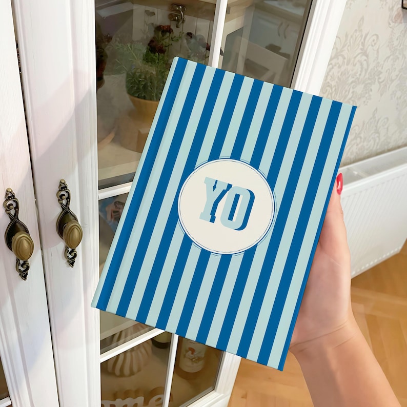 Blue and light blue striped personalized notebook held in hand, featuring monogrammed initials on the cover. Elegant hardcover journal with lined perforated pages for writing, journaling, or business planning. Aesthetic blue stripe notebook for students, professionals, or creative writers. Custom name notebook ideal for office use, school, or gifting. Stylish personalized stationery perfect for daily organization, note-taking, or thoughtful personalized gifts.