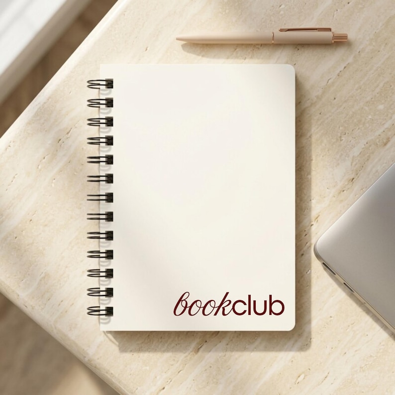 Blush pink spiral notebook featuring elegant white logo design displayed on a modern workspace desk with plant decor. Ideal for personalized business stationery, feminine branding, or executive office planners. Perfect for client gifts, event branding, and team journals. Aesthetic spiral notebook for creative professionals, business owners, and entrepreneurs who value modern, custom design office supplies.