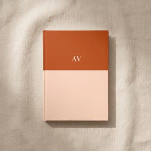 Flat lay of a personalized burnt orange and blush color block hardcover notebook with gold monogram initials on a soft neutral linen background, luxury stationery gift, custom journal, elegant desk accessory, premium writing notebook, modern monogram planner, personalized note taking journal, aesthetic office notebook, gift for professionals, bridesmaid gift idea, office organization stationery, high end paper goods, daily planner, and journaling notebook for work and school.