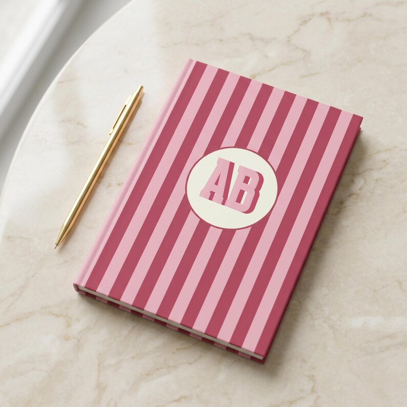 Burgundy and pink striped personalized notebook with custom initials on the cover. Elegant monogrammed journal featuring perforated lined pages for writing, planning, or note-taking. Aesthetic hardcover diary perfect for students, professionals, and gift-giving. Custom name notebook for journaling, office, or school use. Stylish pink stripe stationery gift for teachers, coworkers, or friends who love personalized and chic writing essentials.