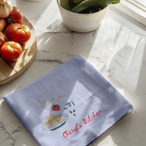 Botanical kitchen towel draped across elegant oven bar, watercolor blossom artwork, spring cottage furnishing, culinary enthusiast accessory, upscale entertaining detail, airy breakfast nook styling, pastel floral textile, charming domestic accent, handcrafted aesthetic, feminine cooking decor, tasteful laundry cloth, curated apartment furnishing, rustic chic presentation, sophisticated dining atmosphere, everyday household staple, luxury homemaker essential, refined baking setup