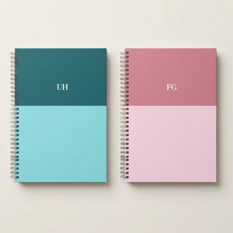 A premium personalized navy notebook with white monogram initials placed at the top center sits on a soft textured gray surface beside a white keyboard and wireless mouse. The hardcover journal features a modern minimalist layout ideal for planners, writers and students. This custom stationery item is shown in a flat lay style that highlights the elegant color tone and professional gift ready design.