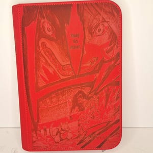 Può includere: Raccoglitore rosso con cerniera con un'illustrazione in stile manga. La copertina mostra una scena dettagliata e ricca di azione in tonalità di rosso, con le parole "TIME TO HUNT" visibili. Il raccoglitore è rettangolare con angoli arrotondati.