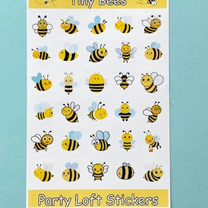 May include: A sheet of stickers featuring cartoon bees in various poses. The stickers are yellow and black with blue wings and white accents. The text "Tiny Bees" and "Party Loft Stickers" are printed on the sheet.