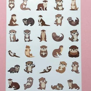May include: A sticker sheet titled Tiny Otters and Party Loft Stickers featuring twenty-five individual illustrations of brown otters in various poses, including sitting, swimming, and waving, arranged in a grid on a white rectangular background.