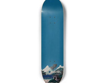 May include: A skateboard deck with a blue background and a scenic illustration. The illustration depicts a coastal landscape with a building, trees, and clouds. The deck has four pre-drilled holes for mounting trucks.