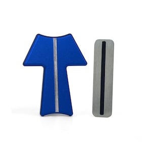 May include: Two metal objects on a white background. One is a blue, T-shaped piece with a silver stripe down the centre. The other is a rectangular, silver piece with a black stripe down the centre. Both have a brushed metal finish.