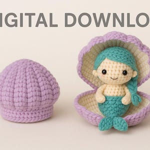 Può includere: Una bambola sirena all'uncinetto con coda e capelli turchesi è seduta all'interno di una conchiglia lilla. Un cappello all'uncinetto lilla abbinato è accanto alla conchiglia. Il testo "DIGITAL DOWNLOAD" è in alto.