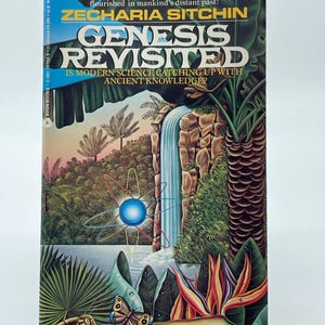 May include: A paperback book titled "Genesis Revisited" by Zecharia Sitchin. The cover shows a jungle scene with a waterfall, a blue atom symbol, and the text "Is Modern Science Catching Up With Ancient Knowledge?"