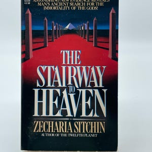 May include: A paperback book titled "The Stairway to Heaven" by Zecharia Sitchin. The cover shows a red path leading to a pyramid, with the title in large white letters. The book is an Avon publication.