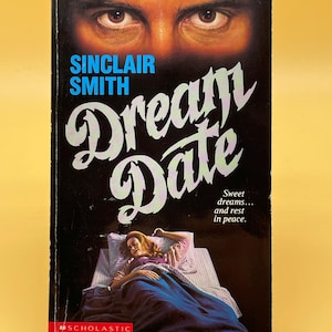 May include: A vintage paperback book titled "Dream Date" by Sinclair Smith. The cover features a dark background with the title in a stylized font, a woman in bed, and a close-up of a man's eyes. The Scholastic logo is at the bottom.