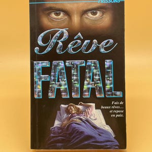 May include: A book cover with the title "Rêve Fatal" in large, stylized letters. The cover features a close-up of eyes above the title and an illustration of a woman sleeping in bed. The text "Fais de beaux rêves... et repose en paix" is also visible.