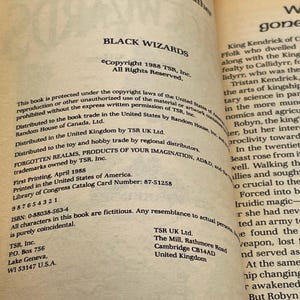 Op de afbeelding: Open boekpagina met de titel "BLACK WIZARDS" en copyrightinformatie uit 1988. De tekst bevat details over distributie, druk en ISBN. De pagina komt uit een boek uit de "FORGOTTEN REALMS"-serie.