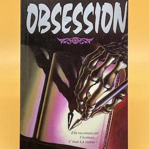 May include: A book cover with the title "OBSESSION" in large white letters. The cover features a skeleton hand holding a pen, writing on a page. The book is a thriller, with the word "FRISSONS" at the top.