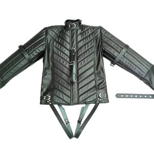 Puede incluir: Chaqueta de cuero negro con diseño acolchado y mangas largas. Cuenta con cuello alto, múltiples correas y hebillas. La chaqueta tiene una apariencia estructurada única.