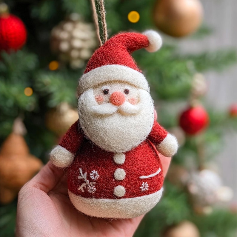 Pode incluir: Enfeite de Natal artesanal em forma de Pai Natal. O enfeite &eacute; feito de feltro vermelho com detalhes brancos, barba branca e nariz rosado. Possui detalhes de flocos de neve e um la&ccedil;o para pendurar.