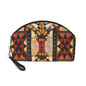 Könnte beinhalten: Eine Kosmetiktasche mit schwarzem Reißverschluss und Handschlaufe. Die Tasche hat ein farbenfrohes geometrisches Muster in Rot-, Orange-, Schwarz- und Cremetönen. Das Design umfasst Rauten und stilisierte florale Elemente.