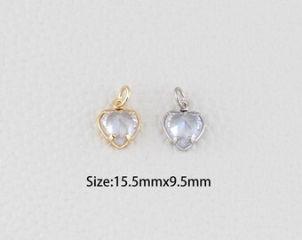 Puede incluir: Dos colgantes en forma de corazón. Uno es dorado, el otro plateado. Ambos tienen una piedra clara en forma de corazón facetado. El texto de abajo dice "Size: 15.5mmx9.5mm".